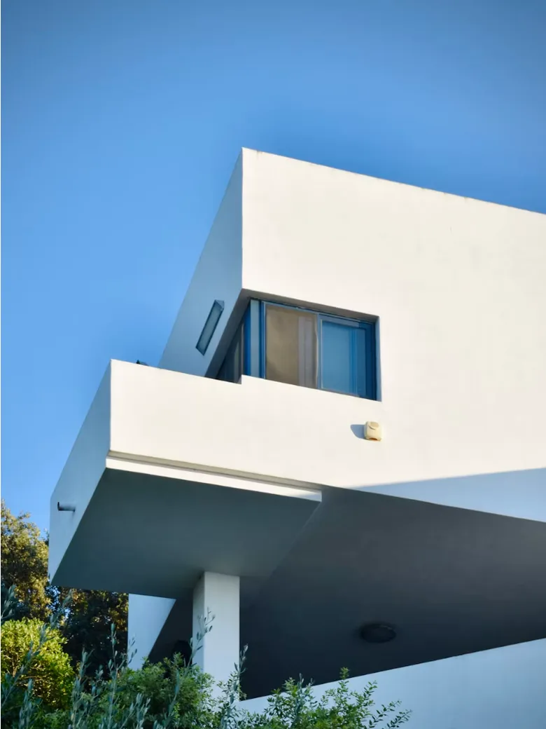 White cantilevered residence with recessed glazing